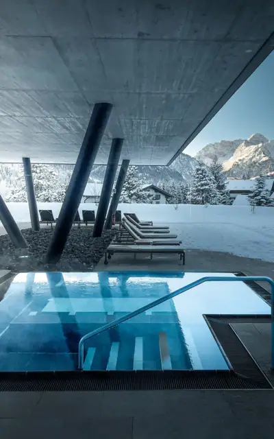 Ein Pool mit einem verschneiten Berg im Hintergrund.