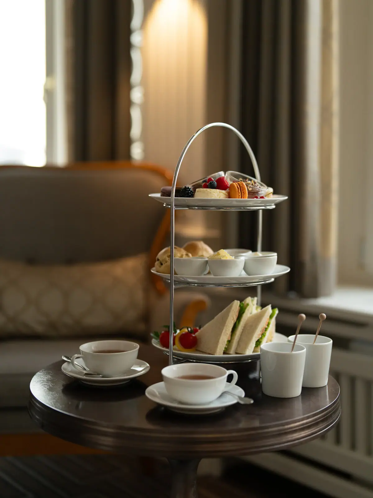Afternoon Tea im Kaminzimmer Dreistöckige Etagere mit Speisen darauf