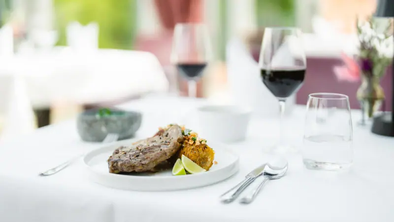 Steak & Wine Ein Teller mit Essen und Weingläsern auf einem Tisch.
