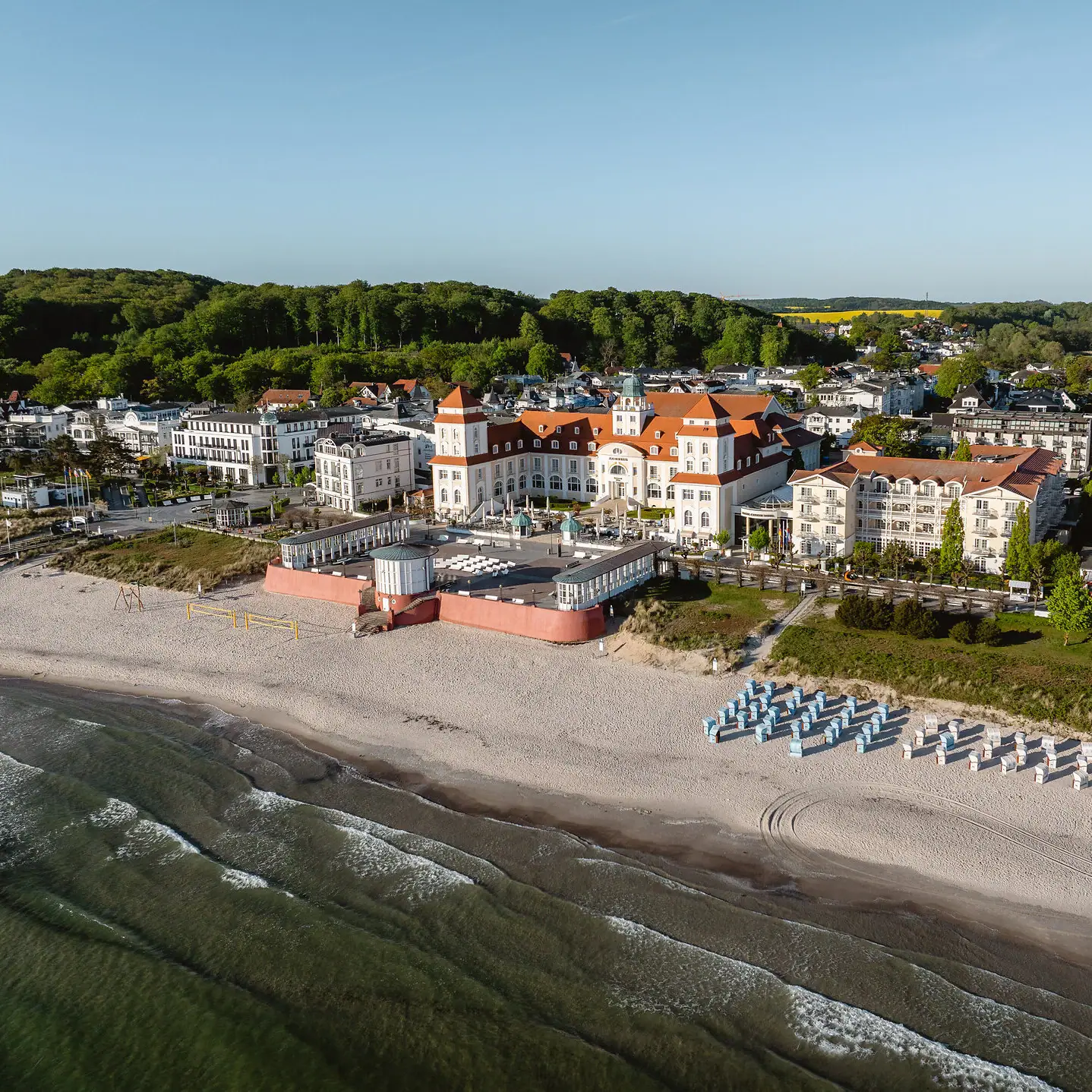 Ein großer Gebäude am Strand mit Stühlen.