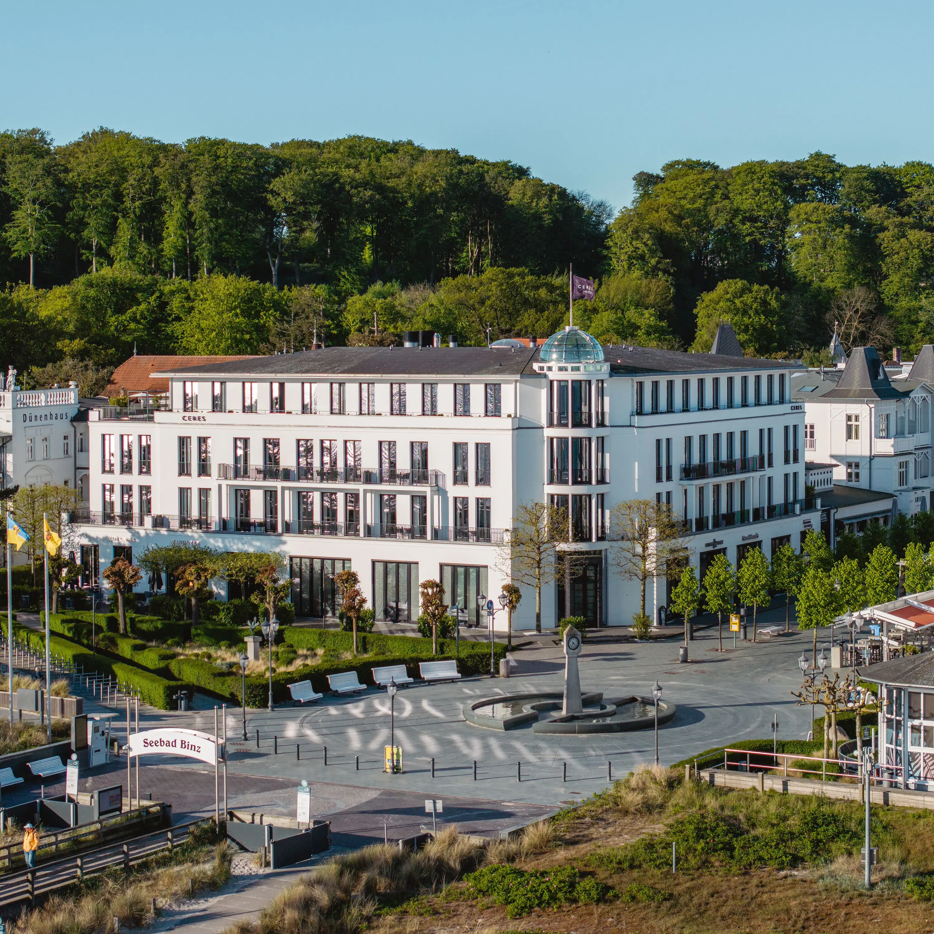 Weißes Gebäude mit Bäumen im Hintergrund