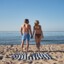 Mann und Frau halten Hände am Strand.