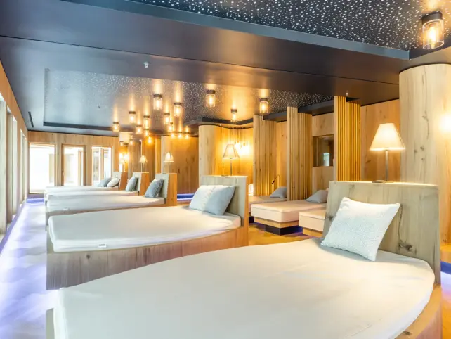Innenansicht eines elegant gestalteten Hotelzimmers mit Betten, Kissen und dekorativen Lichtern.