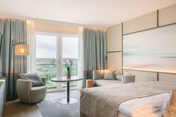 Hotelzimmer mit Bett, Tisch und Stühlen