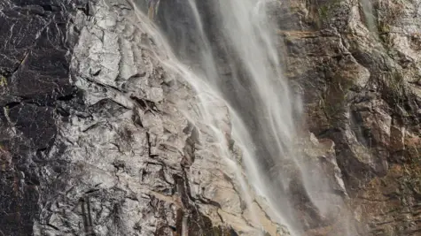 Eine Nahaufnahme eines Wasserfalls an einer Felswand.