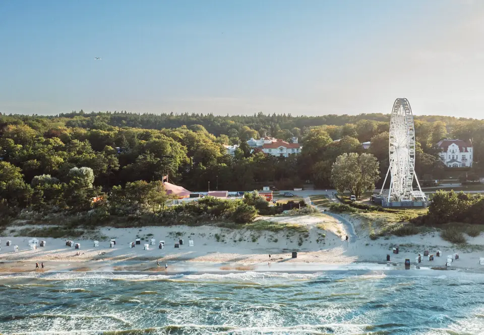 Strand mit einem Riesenrad und Bäumen.