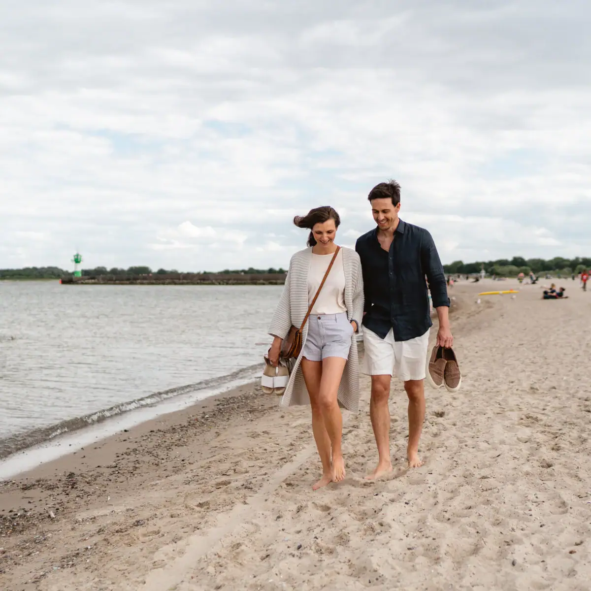 Ein Mann und eine Frau spazieren am Strand.