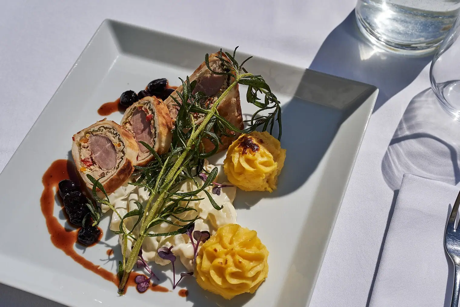 Ein Teller mit kunstvoll angerichtetem Essen auf einem Tisch.