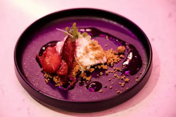 Ein Teller mit Dessert, garniert mit Früchten und Streuseln.