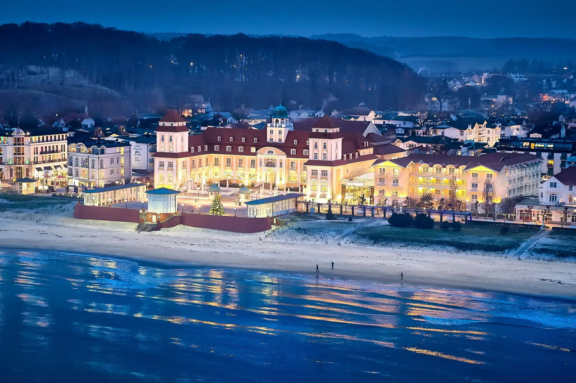 Ein großes beleuchtetes Gebäude an einem Strand.