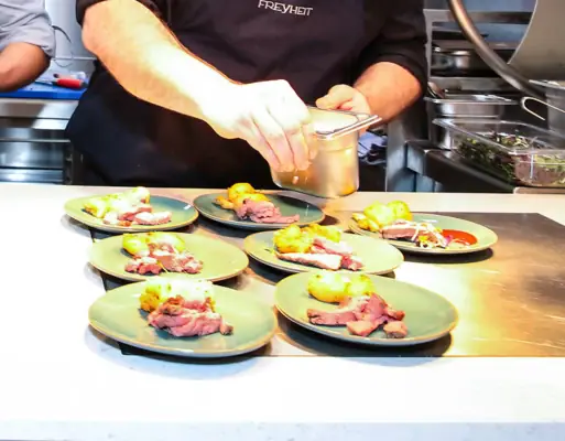 Zwei Männer in einer Küche beim Zubereiten von Speisen.