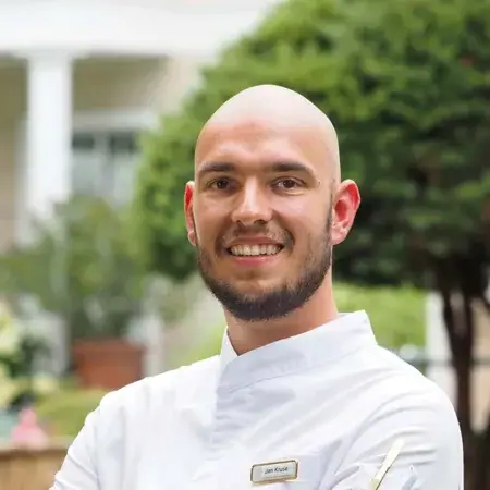 Küchenchef Jan Kruse Ein lächelnder Mann in einem weißen Mantel.