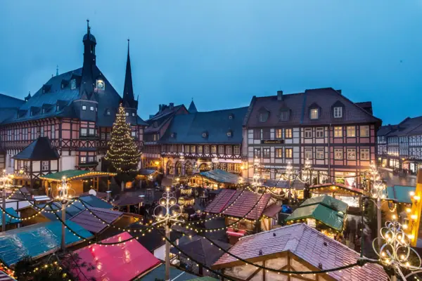 Ein  Marktplatz mit Rathaus und Hotel und einem Weihnachtsmarkt