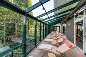 Eine Reihe von Liegestühlen in einem Raum mit Glaswänden.