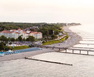 Ein Strand mit vielen Menschen und einem Gewässer.