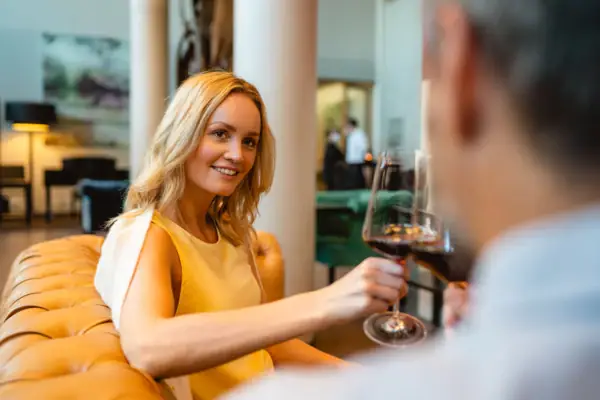 Lifestylebar Frau hält ein Weinglas und lächelt.