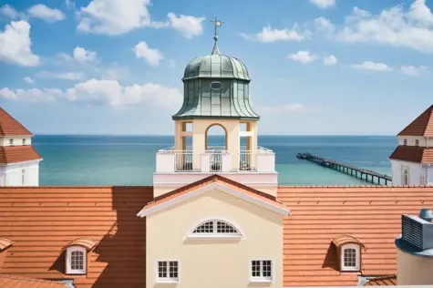 Eine Luftansicht des Turmes vom Kurhaus Binz und dem sich dahinter in sommerlichem Blau erstreckenden Meer. 