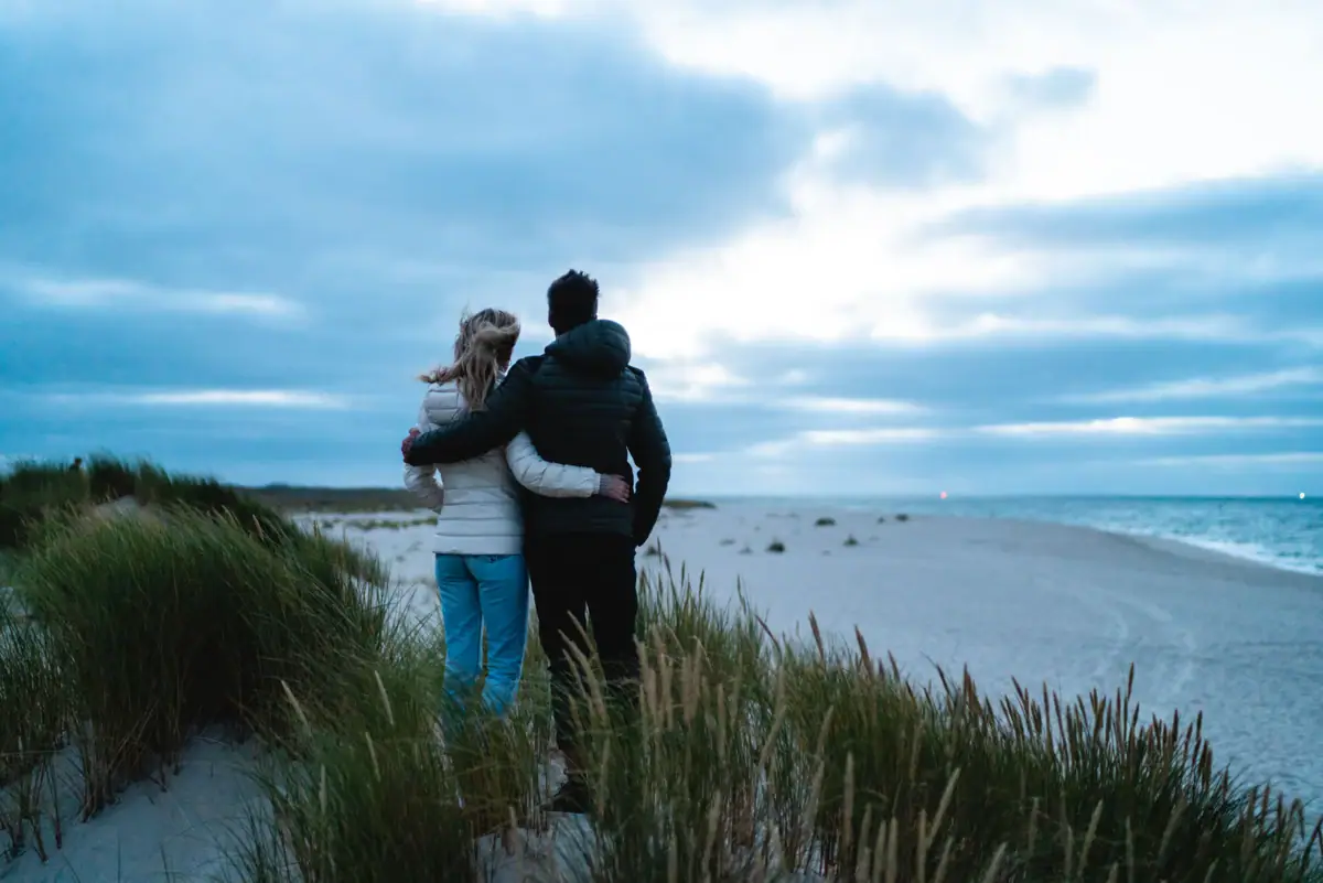 Ein Mann und eine Frau stehen am Strand.