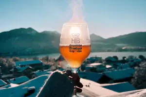 Tegernsee Winter Eine Hand hält ein Glas Wein, aus dem Rauch aufsteigt.