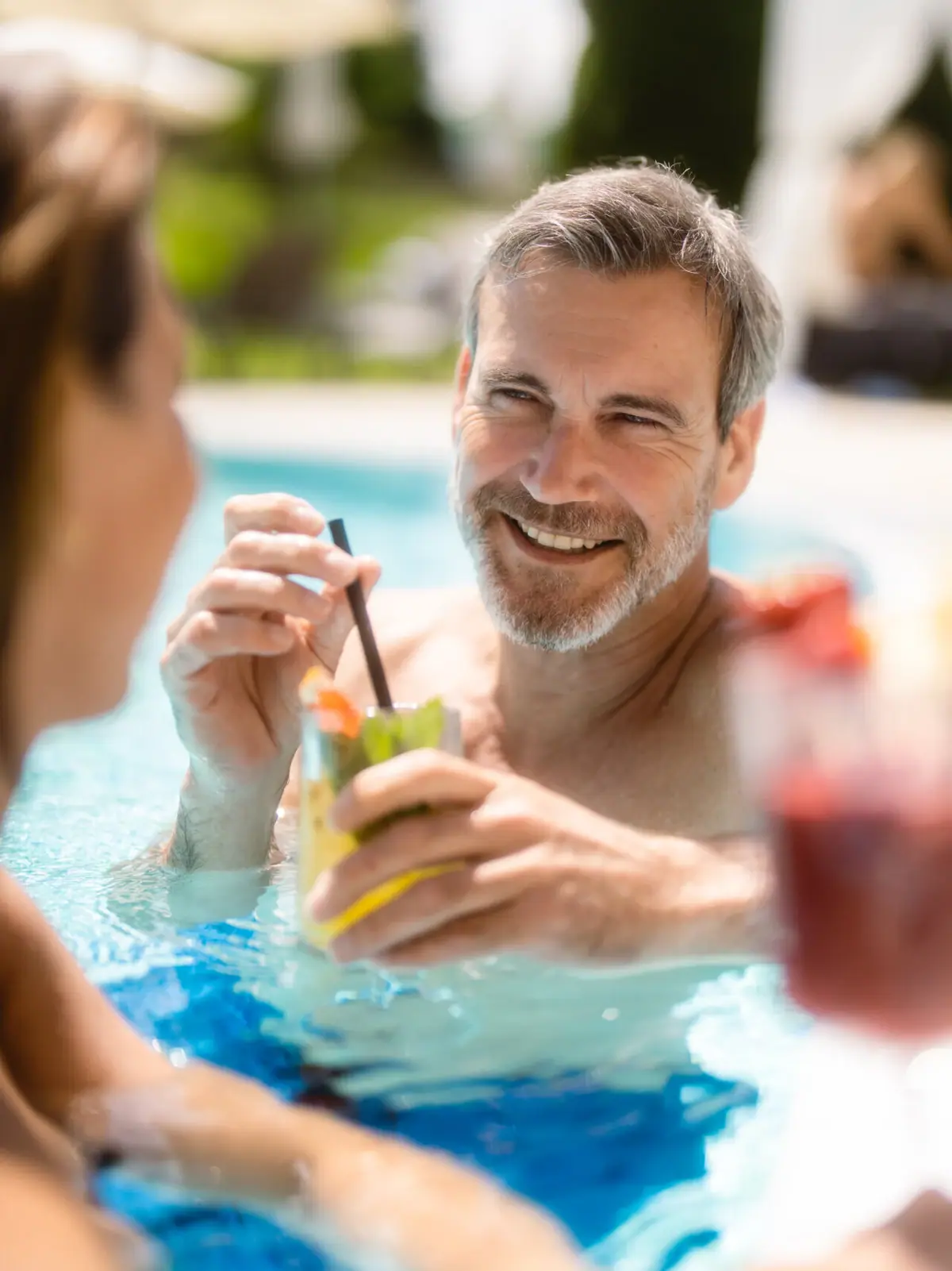 Poolparty Ein Mann und eine Frau lächelnd im Schwimmbecken.