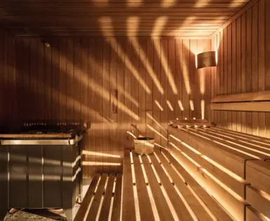 Eine Holzsauna die von leichtem Licht durchleuchtet wird.