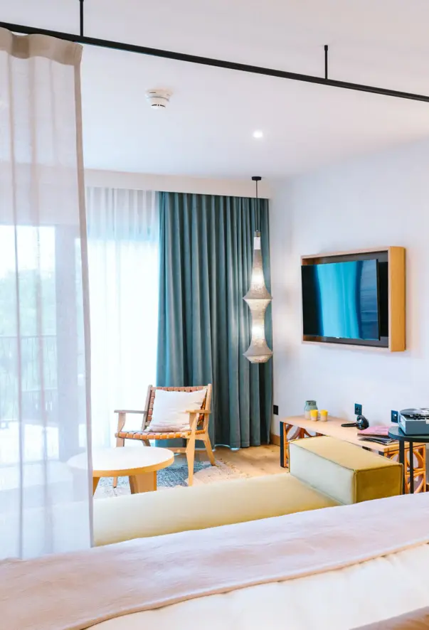 Una suite moderna con un'accogliente zona giorno con poltrone, TV e decorazioni varie. 