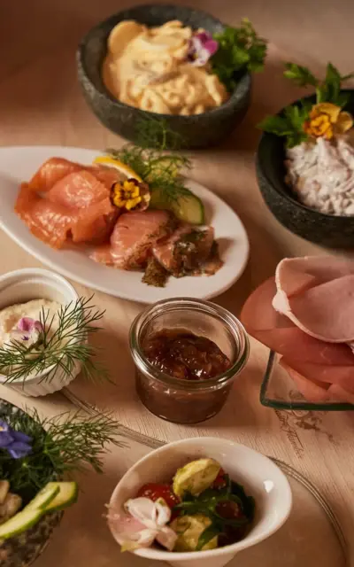 Ein Tisch voller verschiedener Speisen, darunter Platten mit Delikatessen, Gemüse und Meeresfrüchten.