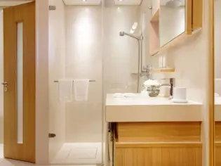 Ein helles Badezimmer mit einer Dusche und einem Waschtisch.