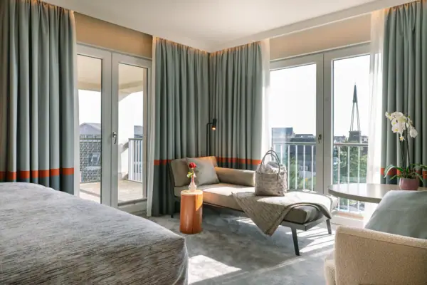 Ein lichtdurchflutetes Hotelzimmer mit einem Sofa und einem Tisch.