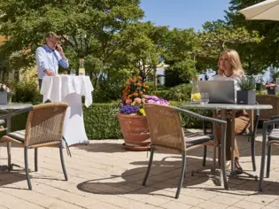 Ein Mann und eine Frau sitzen an einem Tisch im Freien.