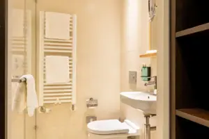 Badezimmer mit Glastür-Dusche und Waschbecken.