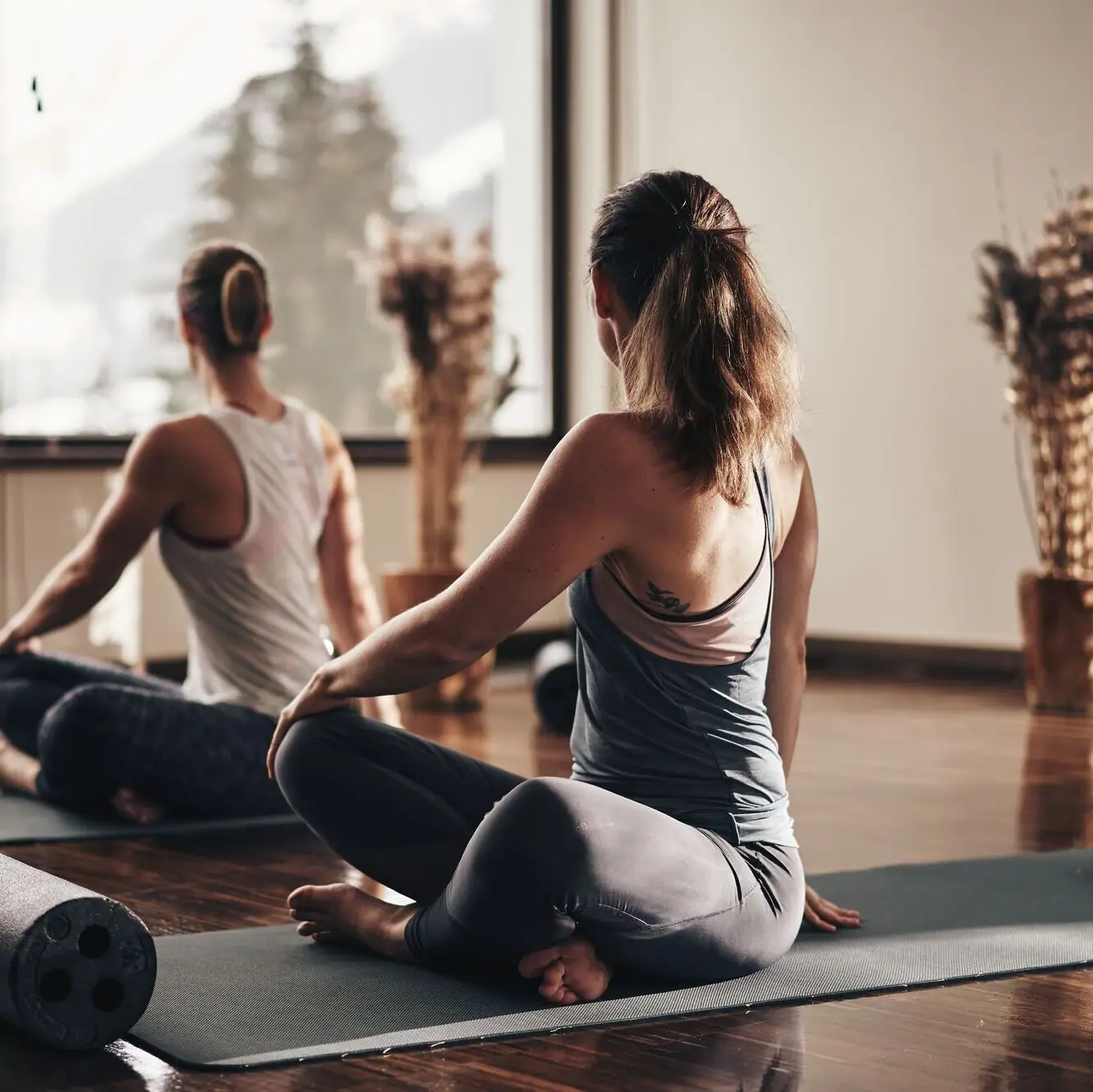 Eine Gruppe von Frauen sitzt auf Yogamatten.