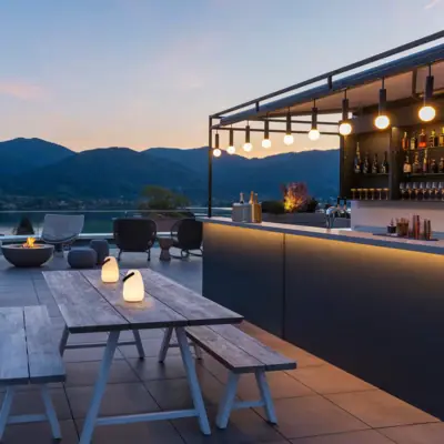 Terrasse mit Tisch, Stühlen und Feuerstelle.