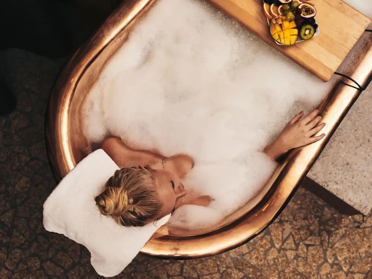 Eine Frau in einer Badewanne mit Schaum.