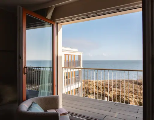 Ein Zimmer mit Balkon und Blick auf den Ozean.