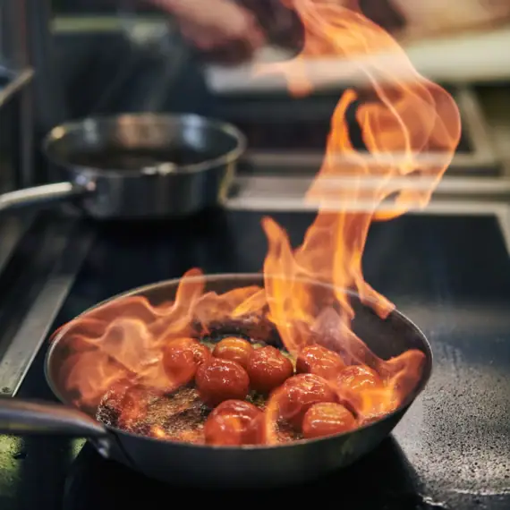 Eine Pfanne mit Essen auf Flammen.