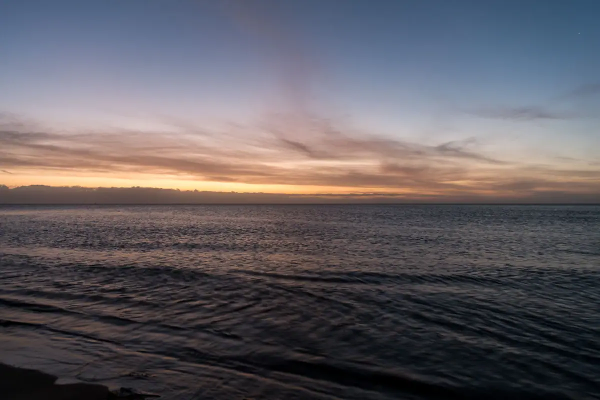 Gewässer bei Sonnenuntergang mit Wolken am Himmel