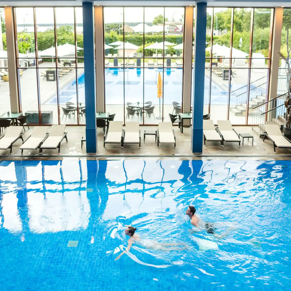 Ein Mann und eine Frau schwimmen in einem Schwimmbecken.