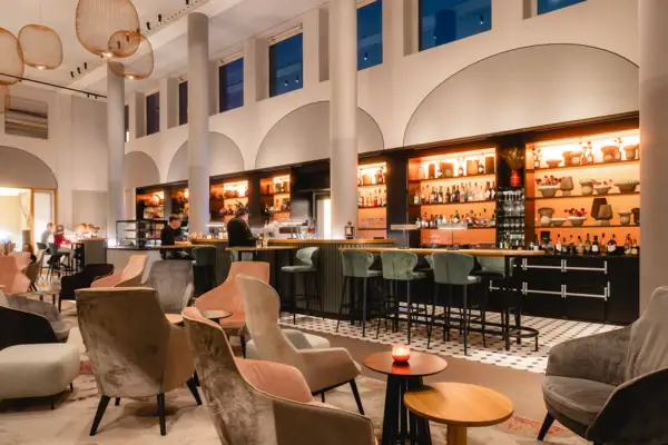 Bar A-ROSA Sylt Eine Bar mit Stühlen und Tischen in einem großen Raum.