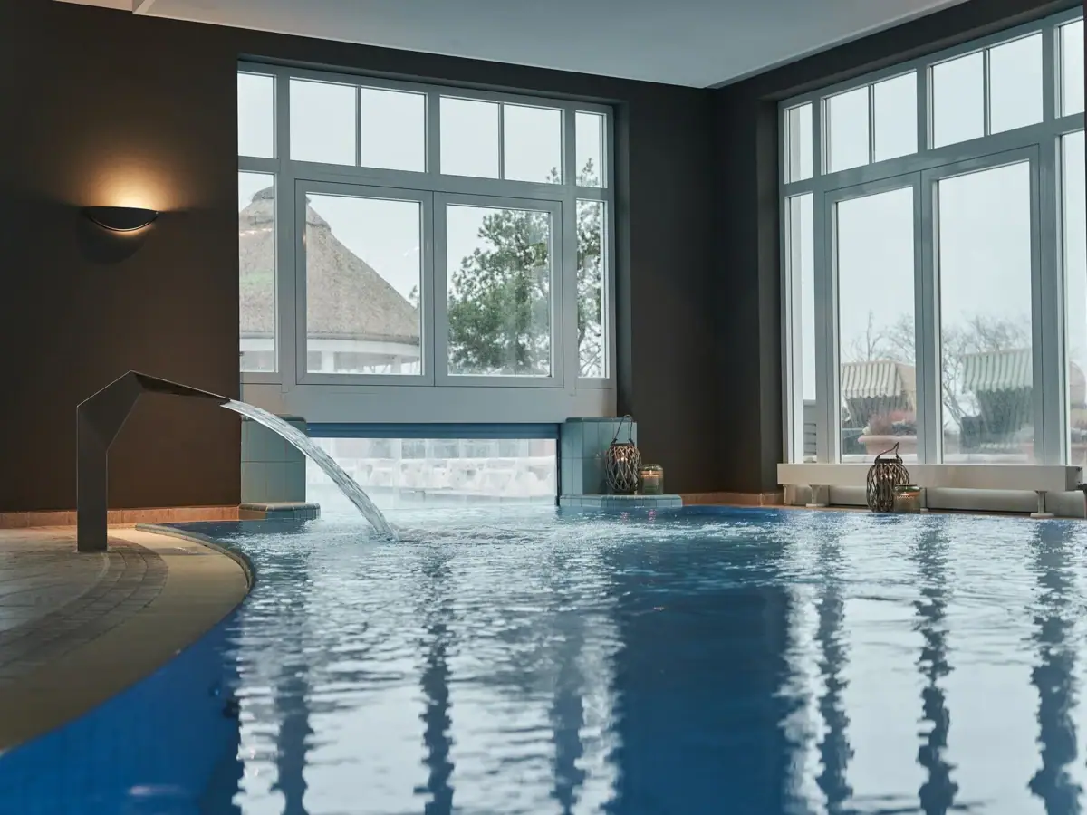 Ein Schwimmbecken mit Wasserfall in einem Innenbereich.
