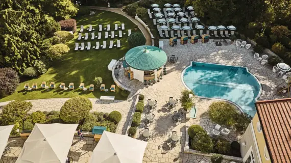 Ein Swimmingpool mit Liegestühlen in einem Garten.