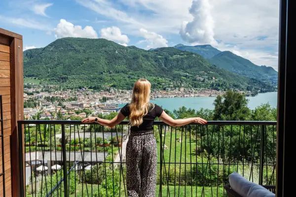 Eine Frau steht auf einem Balkon und blickt auf eine Stadt.