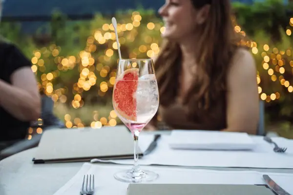 Ein Drink mit einer Scheibe Grapefruit auf einem Tisch im Freien.