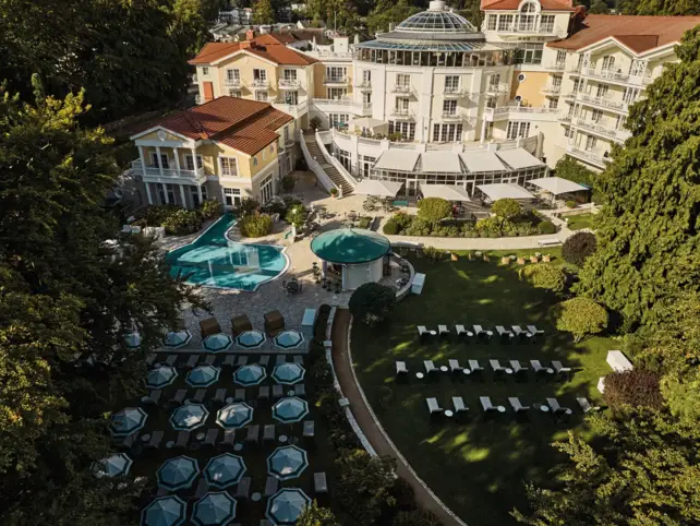 Ein Gebäude mit einem Pool und Liegestühlen im Freien.