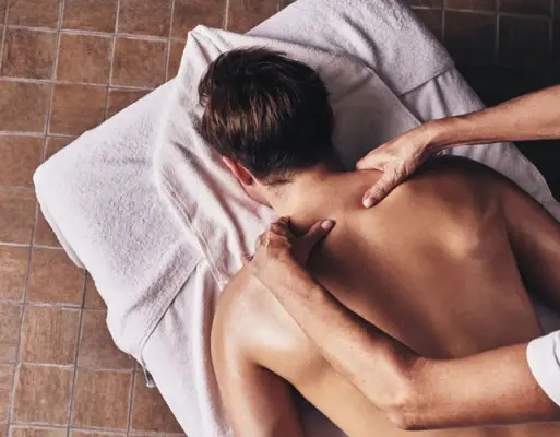 anwendungen im SPA Eine Person erhält eine Rückenmassage.