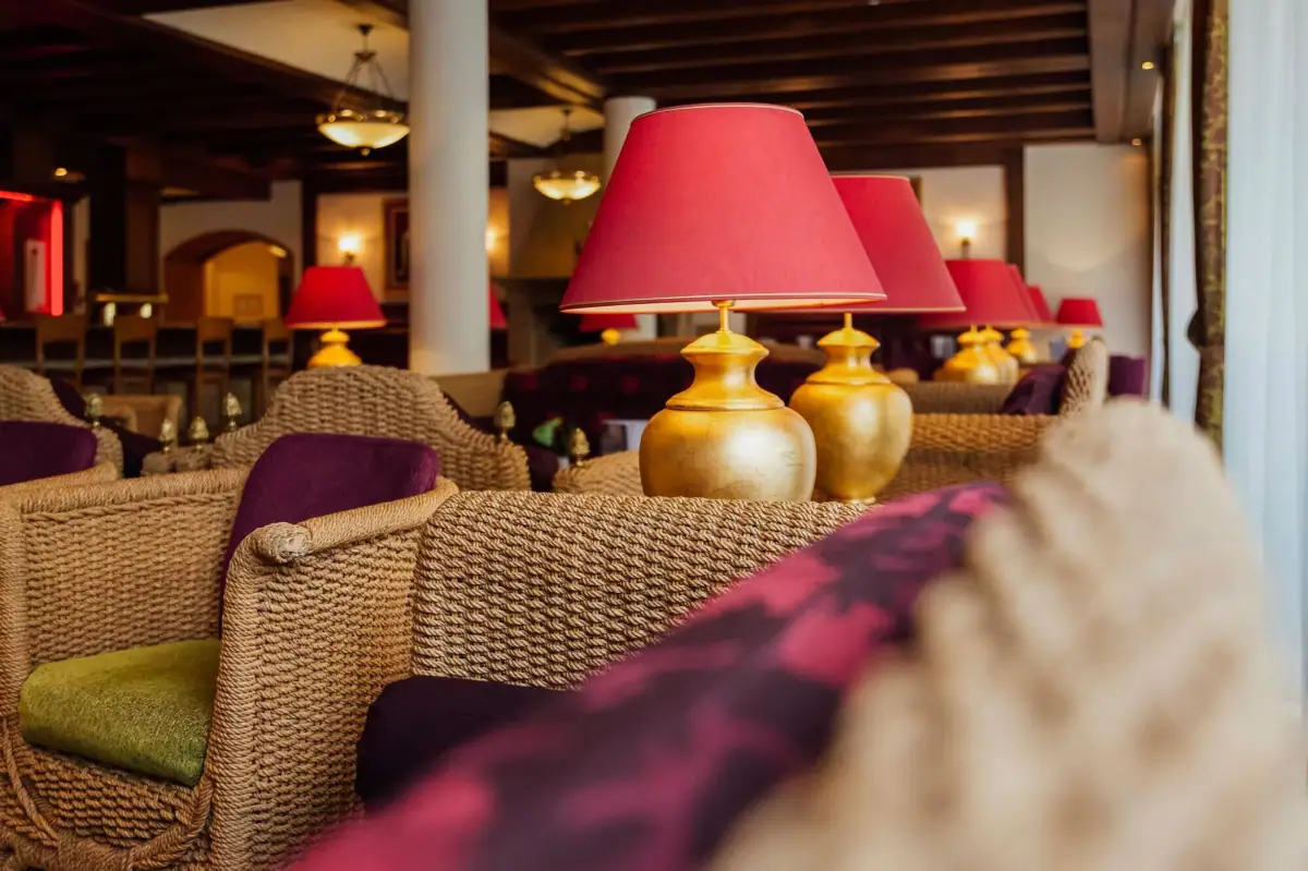 Kaminbar Gothisches Haus Wernigerode Ein Tisch mit Lampen und Stühlen in einem Innenraum.