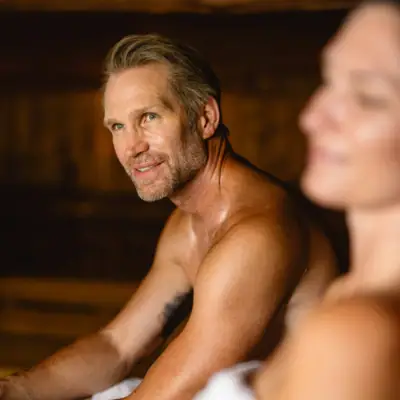 Ein Mann und eine Frau sitzen lächelnd in einem Raum.