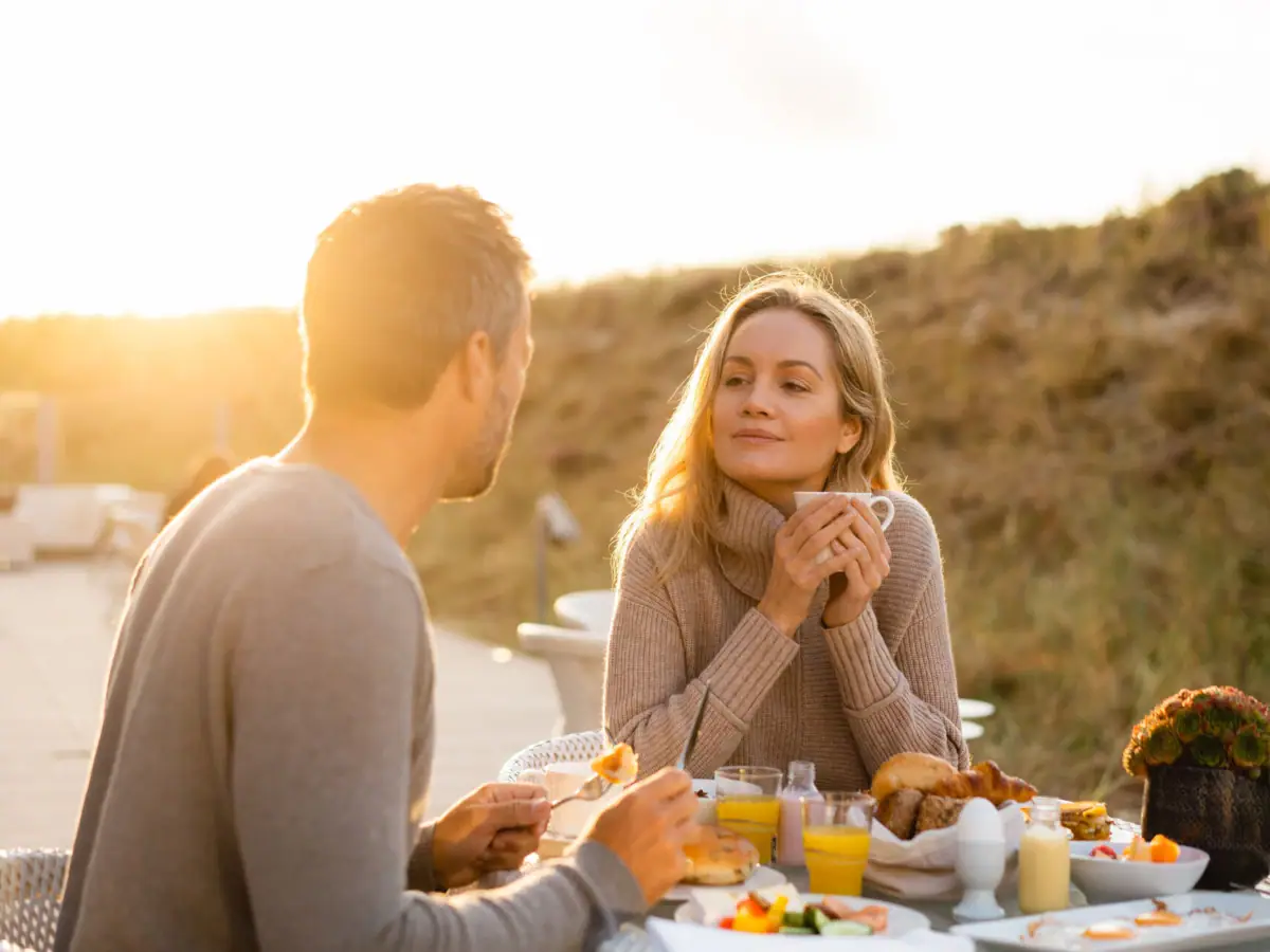 Ein Mann und eine Frau sitzen an einem Tisch mit Essen.