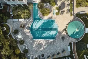 Schwimmbecken im Garten mit Bäumen im Hintergrund.