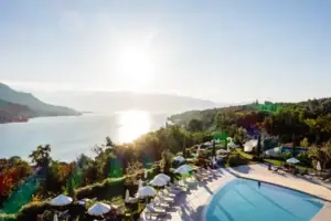 Ein Swimmingpool mit Sonnenschirmen und Liegestühlen am Wasser.